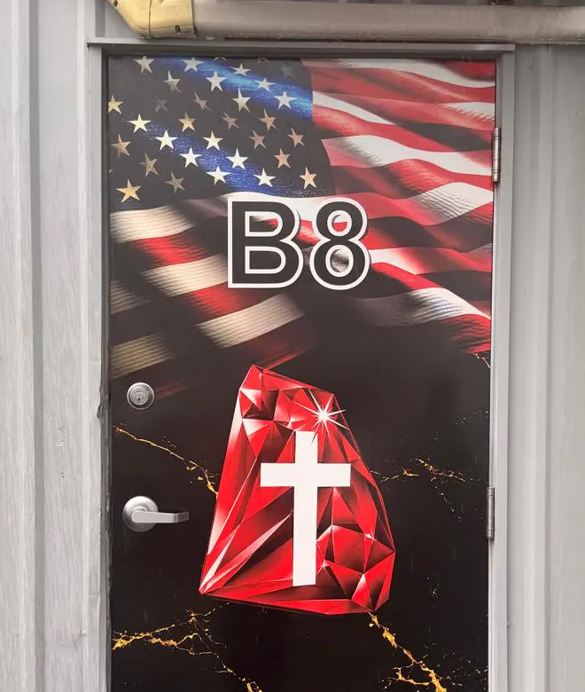 Commercial door with an American flag, B8 identification and red jewel-and-cross graphics.