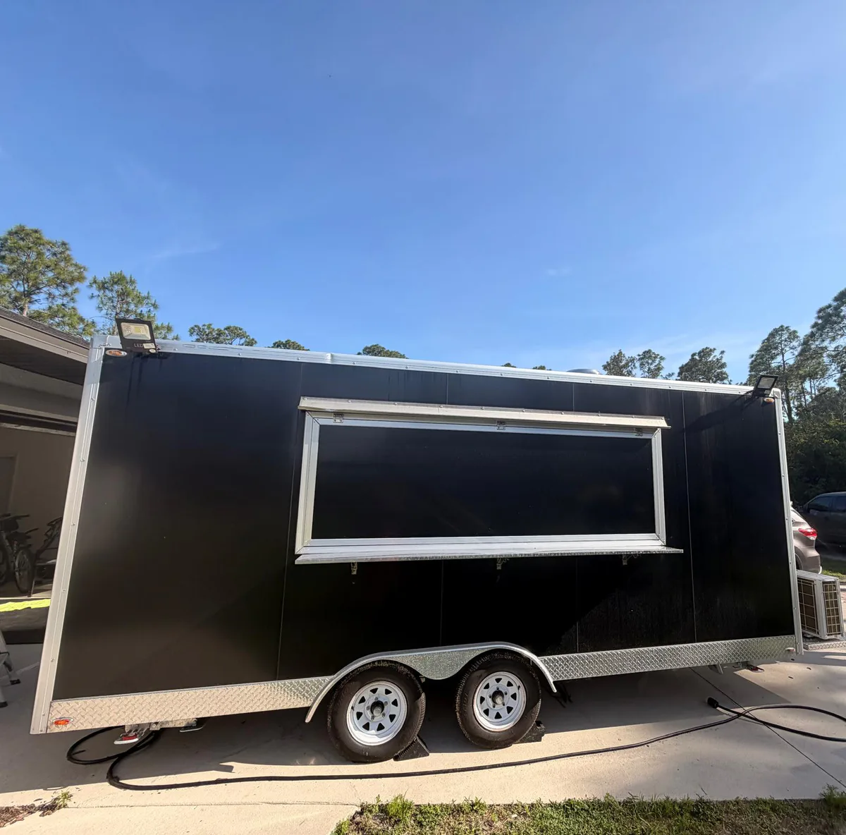 Before: plain black enclosed food trailer without completed graphics.