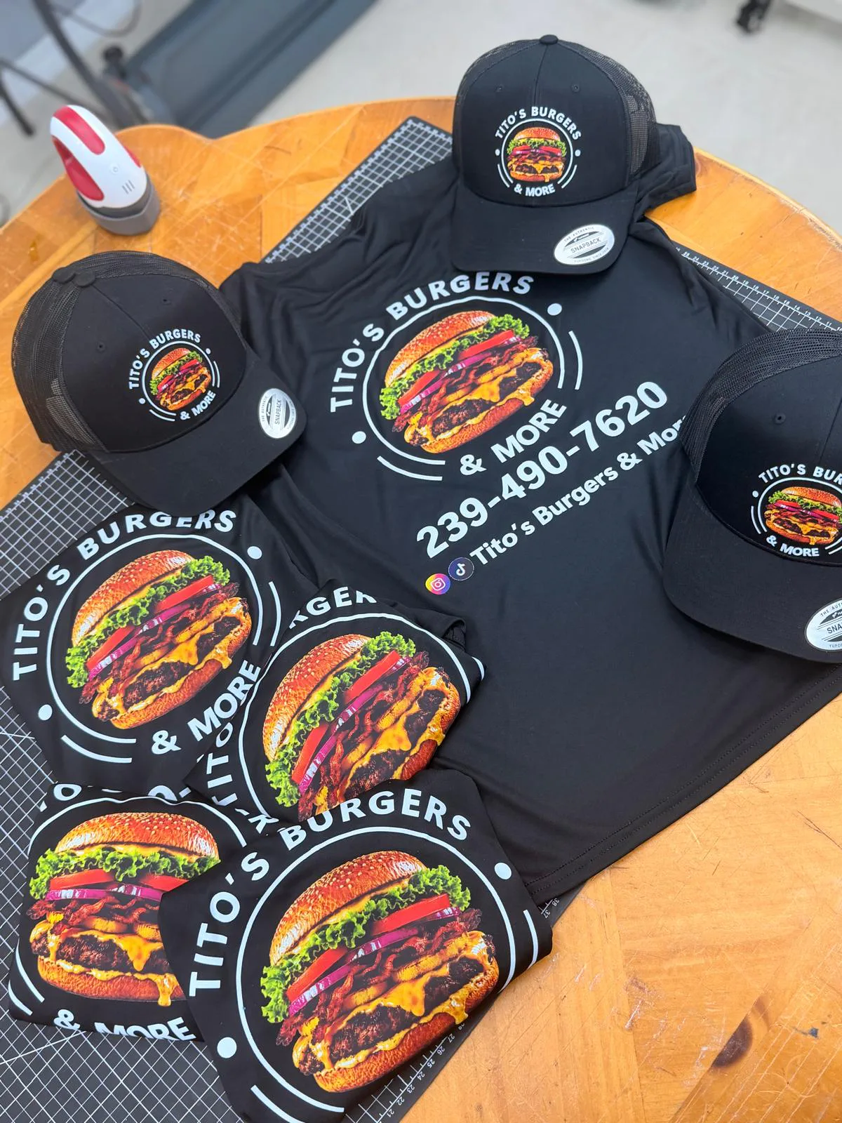 Black branded shirts and caps produced for a local restaurant.